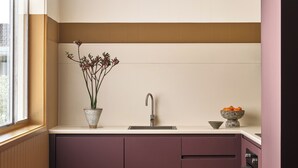 A modern kitchen with a wooden dining table, a built-in sink, and a window providing natural light. - Casita Motel (Batehaven)