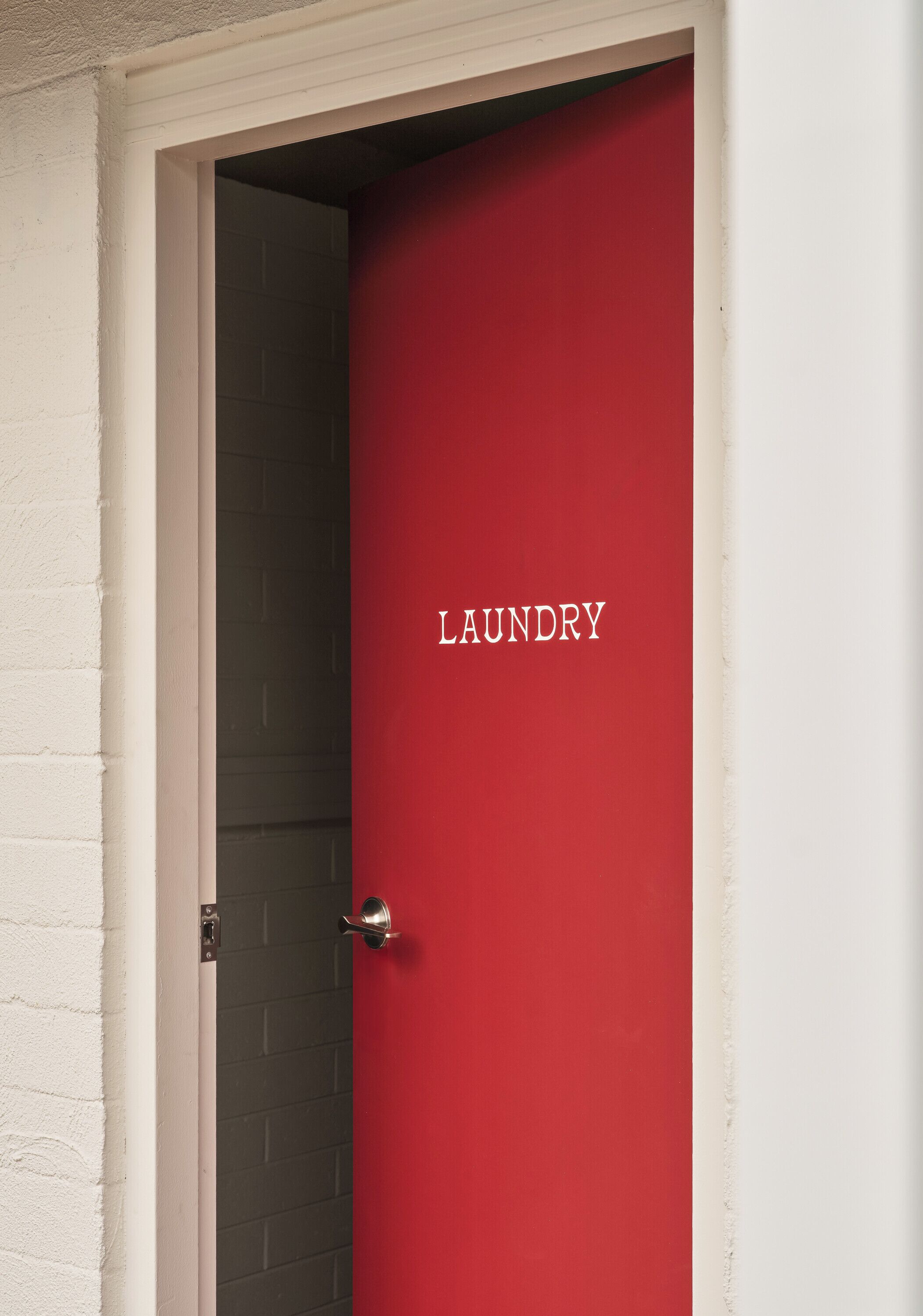 A red door with the word "LAUNDRY" on it.
