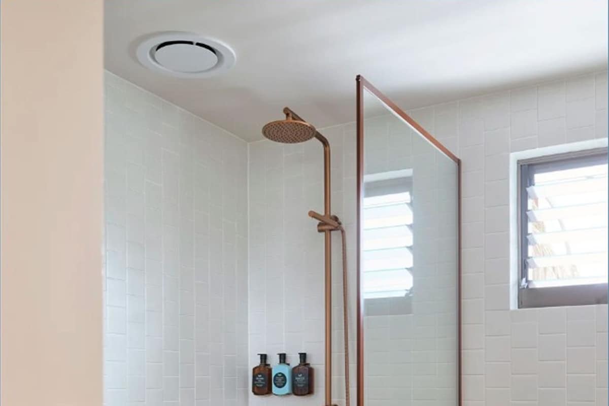 A modern bathroom with a glass-enclosed shower, a white sink, and a toilet.