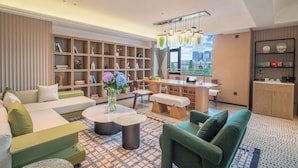 Un salon moderne avec un canapé, une table basse, une bibliothèque et une vue sur la ville.