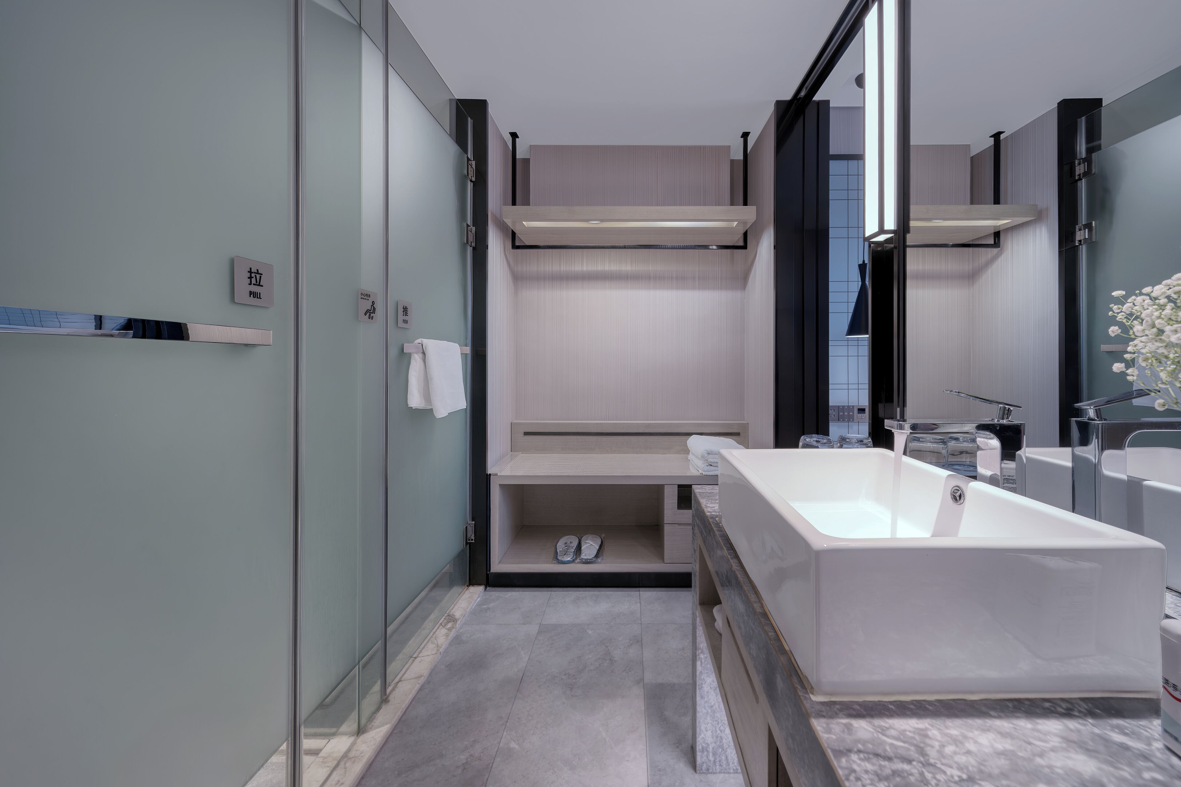 A modern bathroom with a large bathtub, a glass shower enclosure, and a minimalist design.
