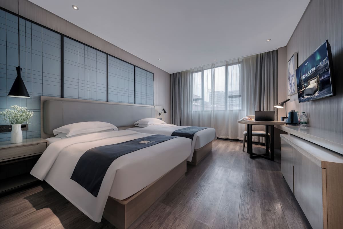 Une chambre d’hôtel moderne avec un grand lit, un bureau et une télévision.