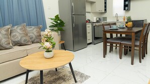 Un salon moderne avec un canapé, une table basse et une plante décorative.