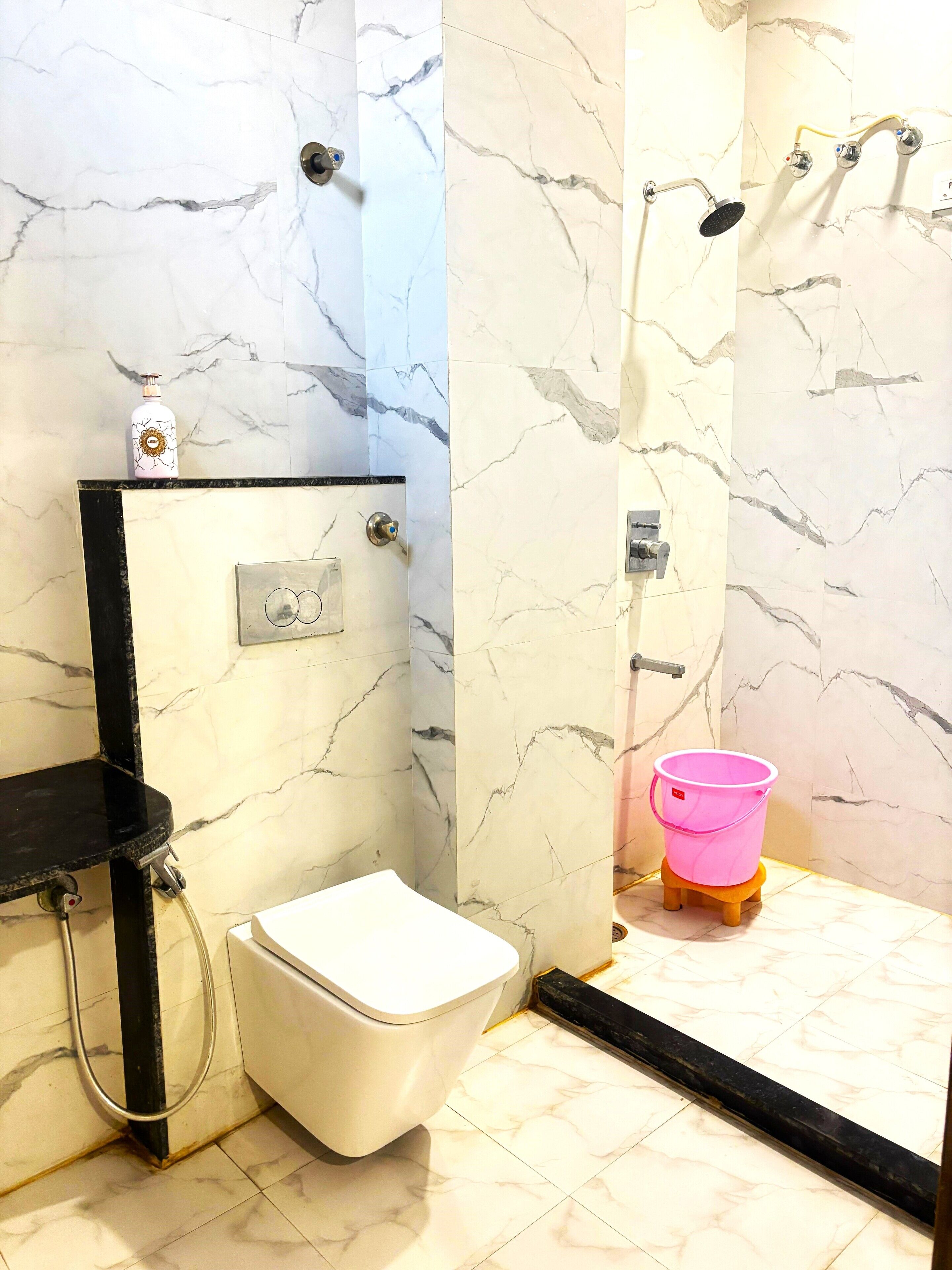 A bathroom with a toilet, a shower, and a sink.