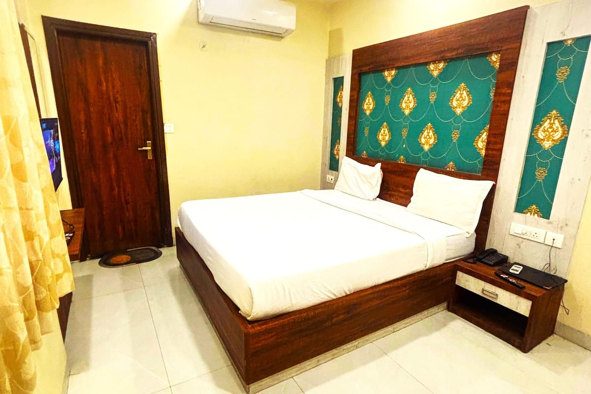 A bedroom with a wooden bed, a nightstand, a ceiling fan, and a wall-mounted air conditioner.