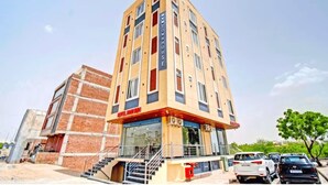 A multi-story hotel with a modern design, featuring a prominent entrance with glass doors and a visible staircase leading to the entrance. - Hotel Hari Inn  (Jaipur)