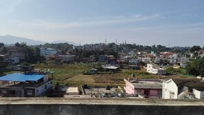 A residential area with houses, a blue-roofed building, and a pink building. - Shanthala Residency (Virajpet)