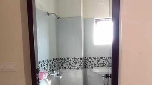 A bathroom with a toilet, sink, and shower. - Shanthala Residency (Virajpet)