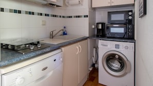 A compact kitchen with a washing machine, a microwave, and a coffee maker. - Bright apartment for 5 ppl, Bright flat for 5 people, close to the sea (Agde)