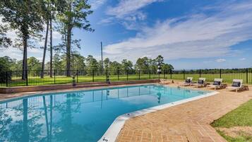 Relax by the serene pool surrounded by lush greenery and comfortable lounge chairs.