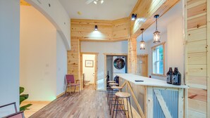 Ein Holzinterieur mit Barbereich, Barhocker und einer Waschmaschine.