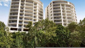 Two cylindrical high-rise buildings with multiple balconies, surrounded by dense greenery. - Zenlux 4BR Waterfront Penthouse Pad 270 Panoroma (Darwin)