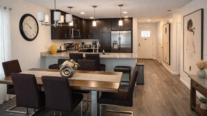 A modern kitchen with dark cabinets, stainless steel appliances, and pendant lighting. - Modern Riverside Home • Sleeps 8 • Near Downtown (Jacksonville)