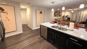 A modern kitchen with granite countertops, stainless steel appliances, and a central island. - Modern Riverside Home • Sleeps 8 • Near Downtown (Jacksonville)