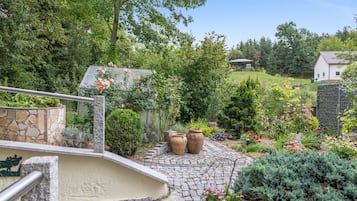 Ein Garten mit einem gepflasterten Weg, der zu einem Haus mit Schindeldach führt.