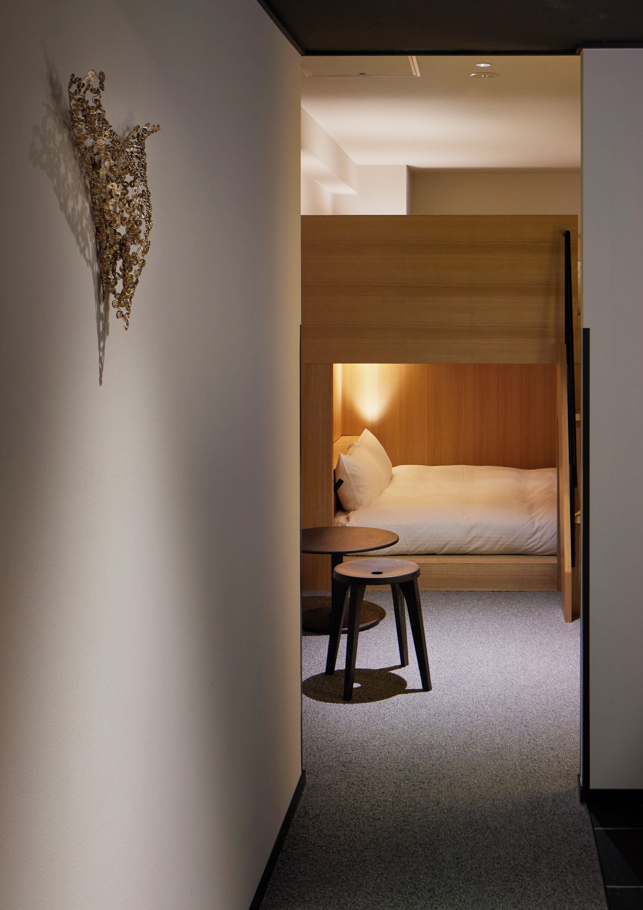 Ein modernes Hotelzimmer mit einem Bett, einem kleinen Tisch und einem einzigartigen Wandbild.