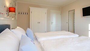 Une chambre d’hôtel équipée d’un lit, d’un bureau, d’une chaise, d’une télévision et d’une armoire.