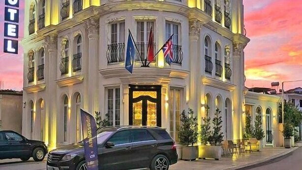 Ein mehrstöckiges Hotel im klassischen Stil mit Balkonen und einer markanten Eingangshalle.
