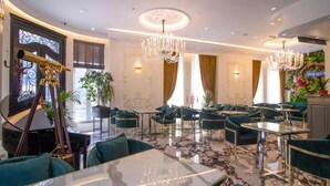 Eine luxuriöse Hotellobby mit einem Flügel, edlen Kronleuchtern und komfortablen Sitzbereichen.