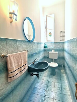 Une salle de bain avec un lavabo, des toilettes et un miroir.