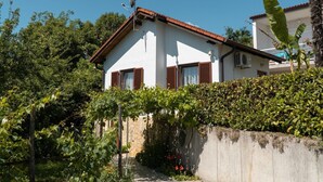 A house with a white exterior, brown shutters, and a satellite dish. - Charming Apartment With Sea Views and Shared Pool (Lovran)