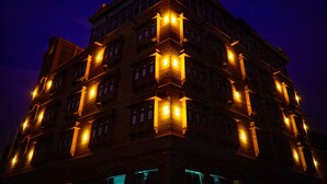 Um edifício de vários andares com janelas de esquina iluminadas e design arquitetônico clássico.