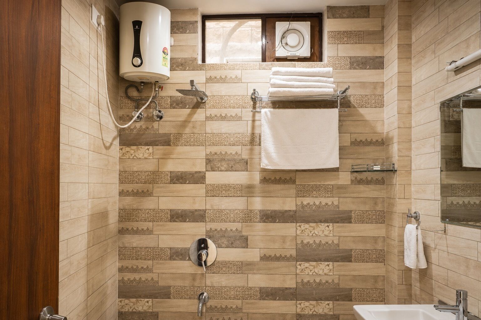 A bathroom with a shower, a toilet, a sink, a towel rack, and a wall-mounted heater.