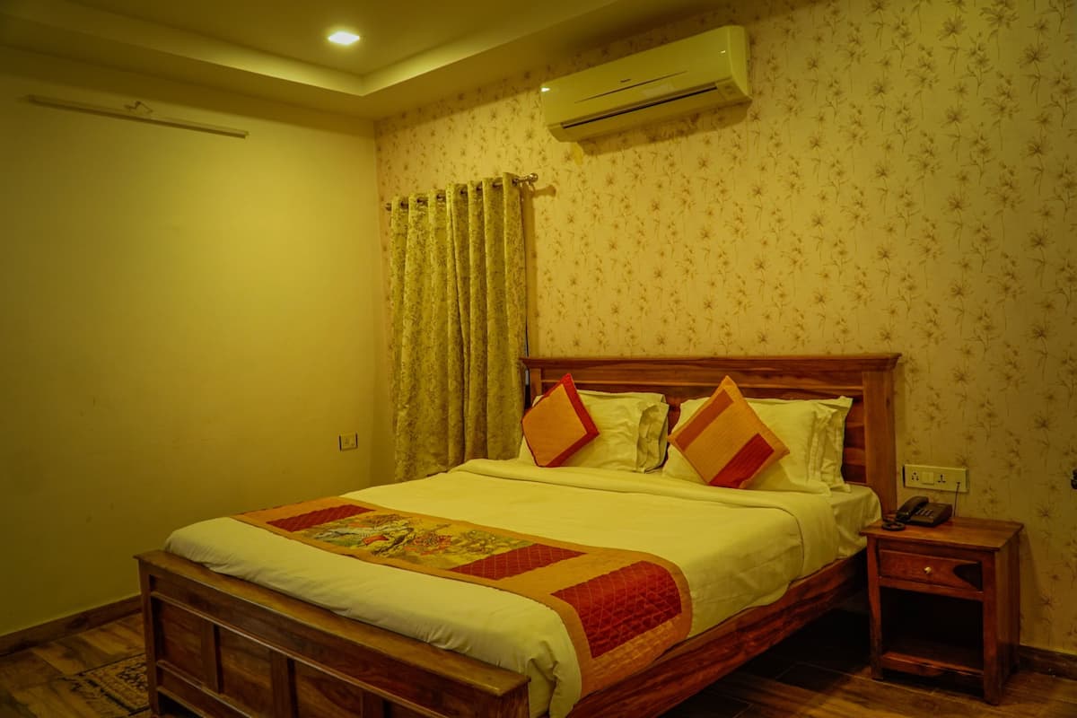 A bedroom with a wooden bed, a bedside table, an air conditioner, and a patterned wallpaper.