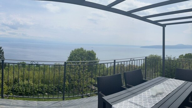 An outdoor patio with a table and chairs, overlooking a body of water and greenery. - Splendid Holiday Home With Panoramic Sea Views Moscenicka Draga (Moscenicka Draga)