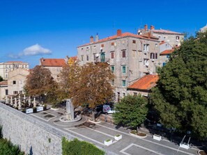 A historic building with a courtyard, stone wall, and trees. - Stylish Two Bedroom Apartment in Labin (Labin)