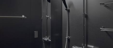 Una ducha moderna con cabezal de ducha manual, panel de control en la pared y un accesorio de ducha de mano.