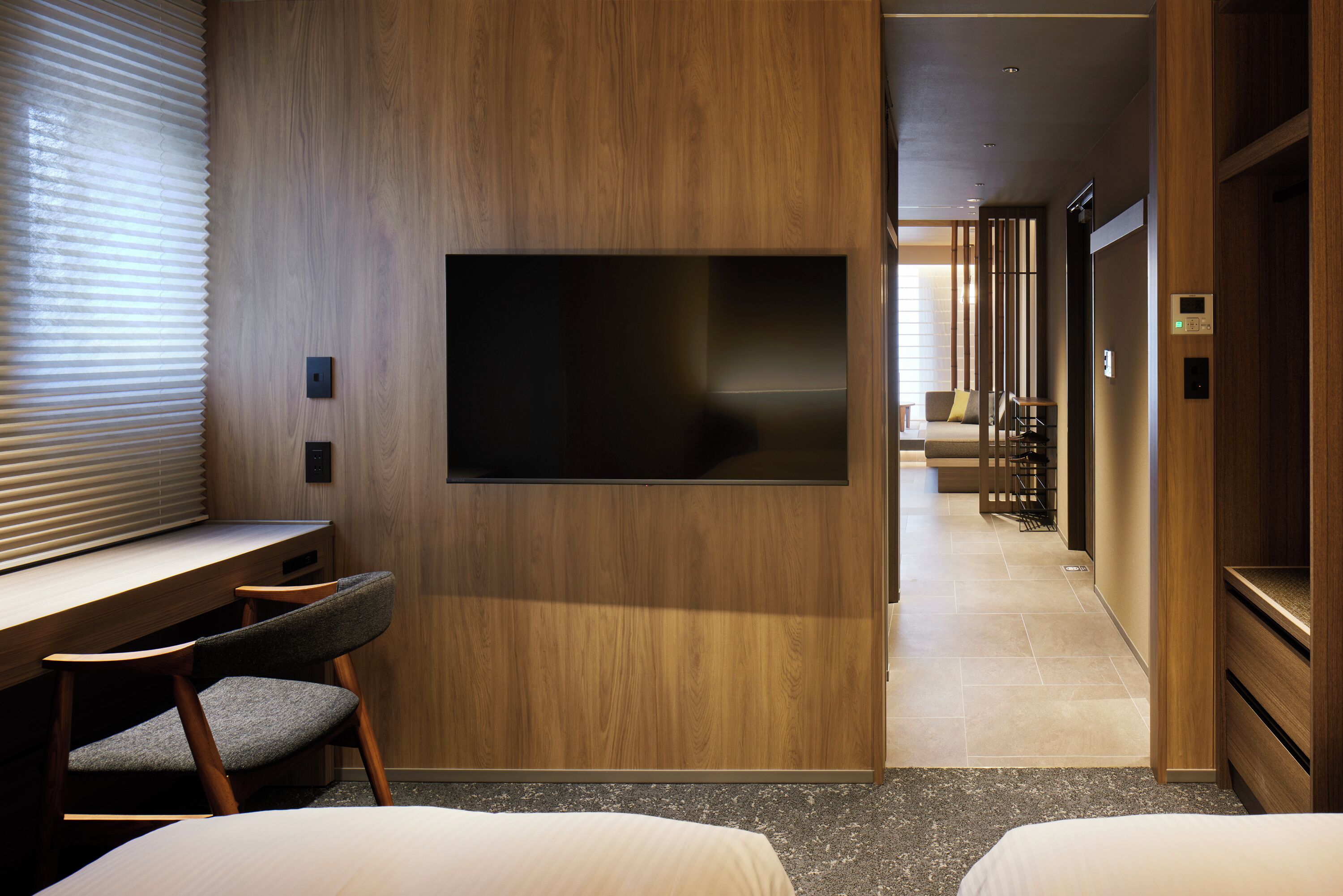 Une chambre d’hôtel avec un mur en bois, un téléviseur à écran plat, un bureau et une chaise.