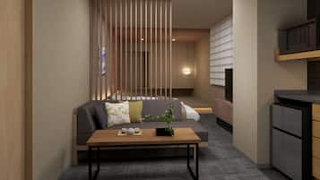 A modern living room with a sofa, a coffee table, and a kitchen area.