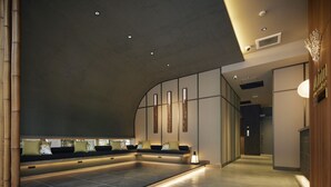 Un moderno espacio de spa con suelo calefaccionado, zona de estar y mostrador de recepción.