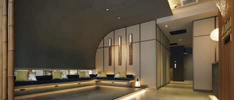 Un moderno espacio de spa con suelo calefaccionado, zona de estar y mostrador de recepción.