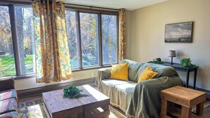 A cozy living room with a sofa, a wooden coffee table, and a side table. - Heated Indoor Private Pool | Stream Front | Game Room (Cresco)