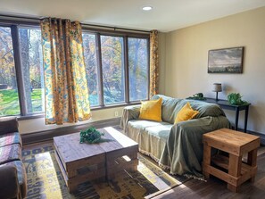 A cozy living room with a sofa, a wooden coffee table, and a side table. - Heated Indoor Private Pool | Stream Front | Game Room (Cresco)