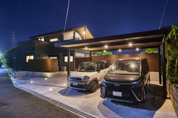 Une maison moderne à deux étages, dotée d’un garage fermé pouvant accueillir deux voitures.
