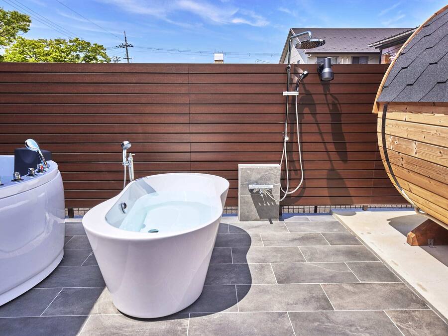 A spa area with a large freestanding bathtub, a separate shower area, and a wooden deck.