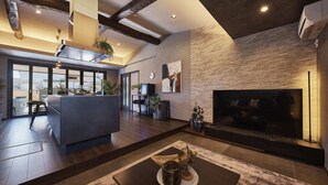 Una sala moderna con un televisor grande, piso de madera oscura y una chimenea.