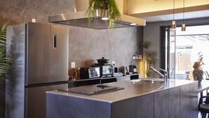 Cocina moderna con una isla central, electrodomésticos de acero inoxidable y un amplio ventanal que proporciona luz natural.