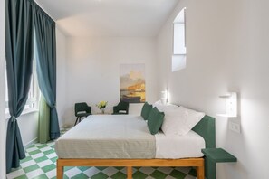 Een slaapkamer met een bed, groene gordijnen, een schilderij aan de muur en een geruite vloer.