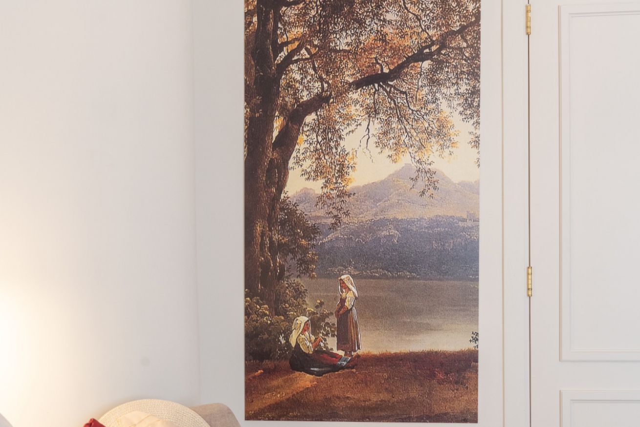 A painting of two figures by a lake, with a mountain in the background.