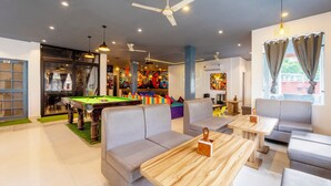 A modern indoor space with a pool table, sofas, and a billiards area. - Treebo AK Residency (Rishikesh)
