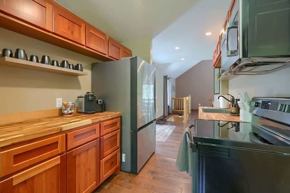 A kitchen with wooden cabinets, a stainless steel refrigerator, and a built-in oven. - Secluded Hocking Hills Cabin with Hot Tub (Ray)