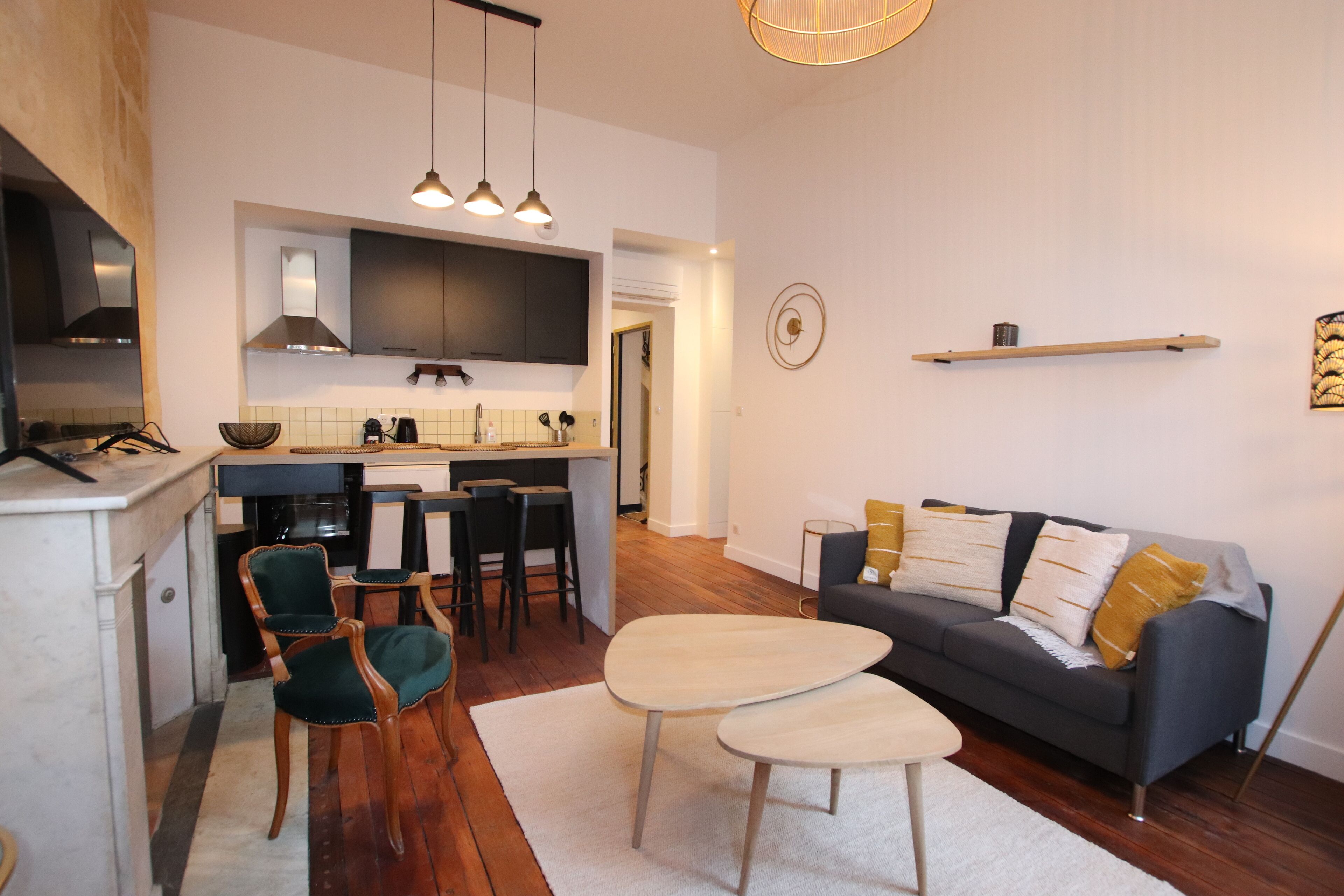 A modern kitchen with a dining area, a sofa, and a coffee table.