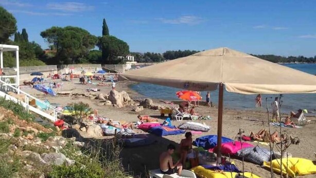 A beach with people sunbathing, umbrellas, and a clear sky. - House IVAS - Umag  (Zambratija)