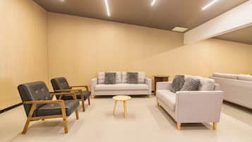 A modern living room with a sofa, two armchairs, and a coffee table.