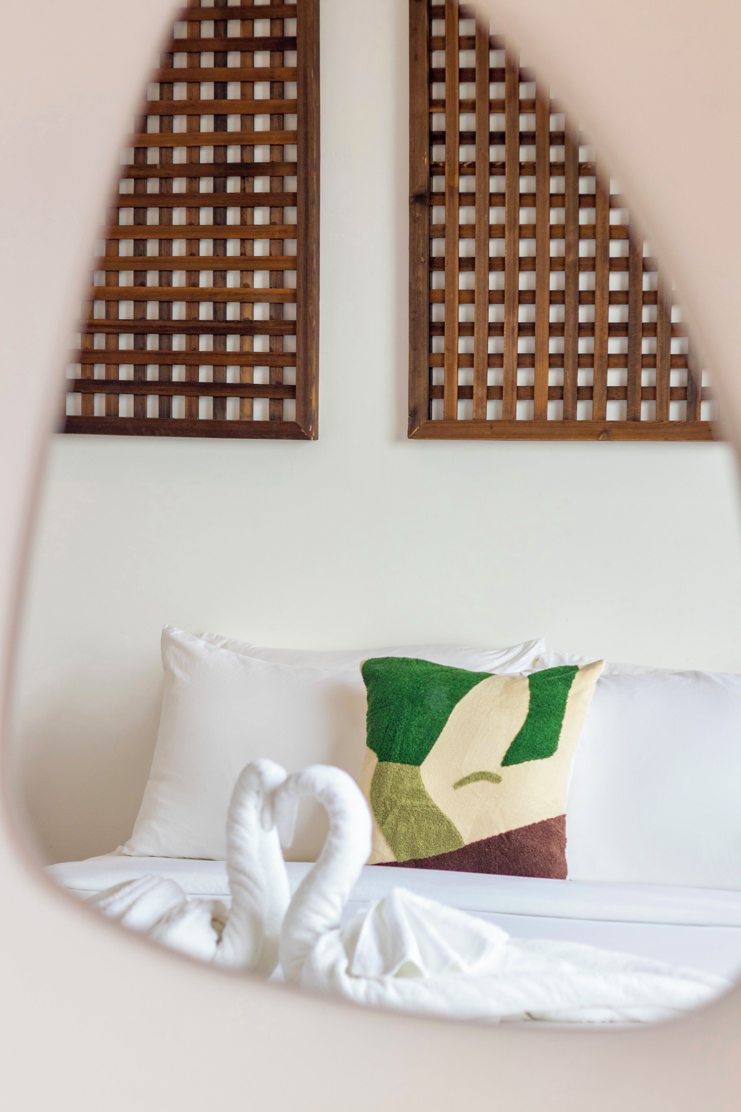 Un lit avec un oreiller blanc et un coussin décoratif à motifs géométriques.