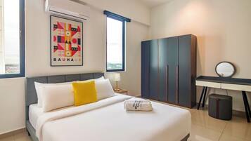 A hotel room with a bed, a desk, a wardrobe, and a window with a view.